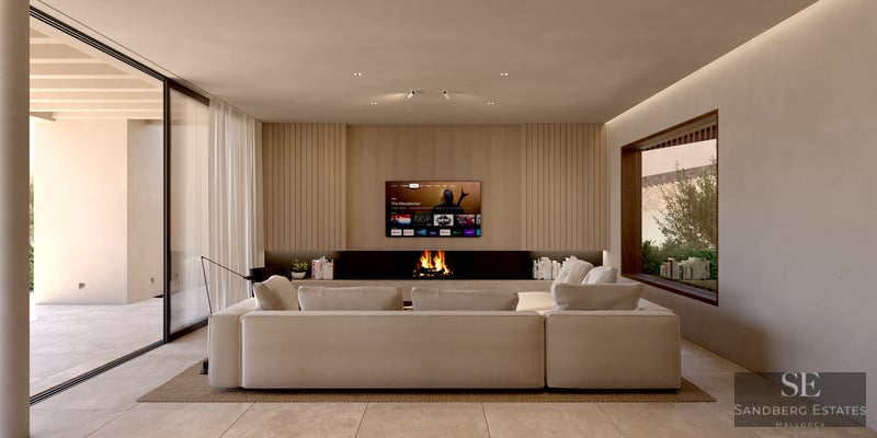 Spacious modern living room featuring a large beige sectional sofa, built-in fireplace, and wood-paneled TV wall.