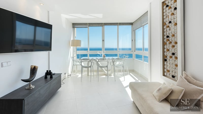 Spacious living room with balcony and sea view. Modern furniture, natural lighting, and neutral color palette. Elegant architecture.
