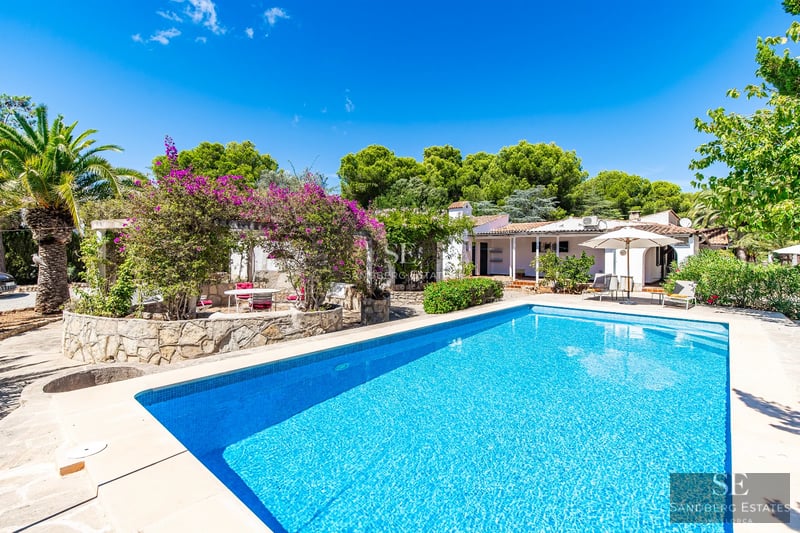 Spacious, bright living room featuring large windows, light wood floors, a modern fireplace, and panoramic sea views. Minimalist and elegant design.
