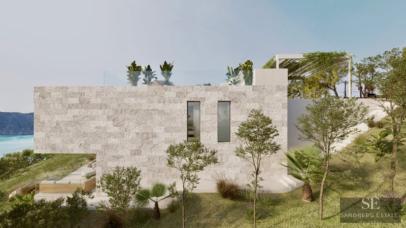 Side view of a modern luxury villa with textured stone walls, rooftop terrace, and Mediterranean landscaping overlooking the sea.