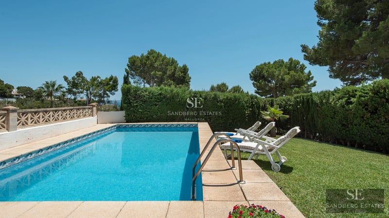 Exterior view of a modern villa with pool, garden and large windows providing ample natural light. Minimalist architectural design.