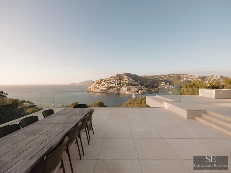 Panoramic view of a villa with an infinity pool. Modern architecture, large windows and lush gardens. Ideal for relaxation.