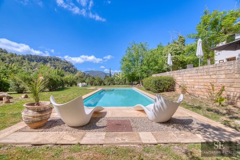 Spacious living room with picture windows, modern fireplace, and designer furniture. Panoramic views. Minimalist decor in neutral tones.