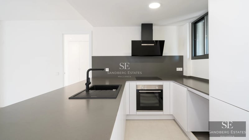 Bright living room leading to a balcony with sea views. Modern design, wooden floors, and elegant furniture. Large windows.