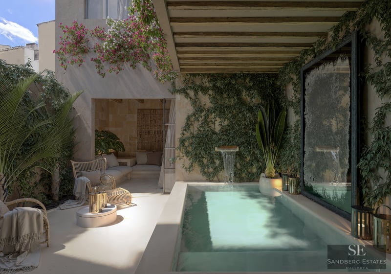 Private plunge pool with waterfall feature surrounded by ivy walls, bougainvillea, and wicker seating under a pergola.