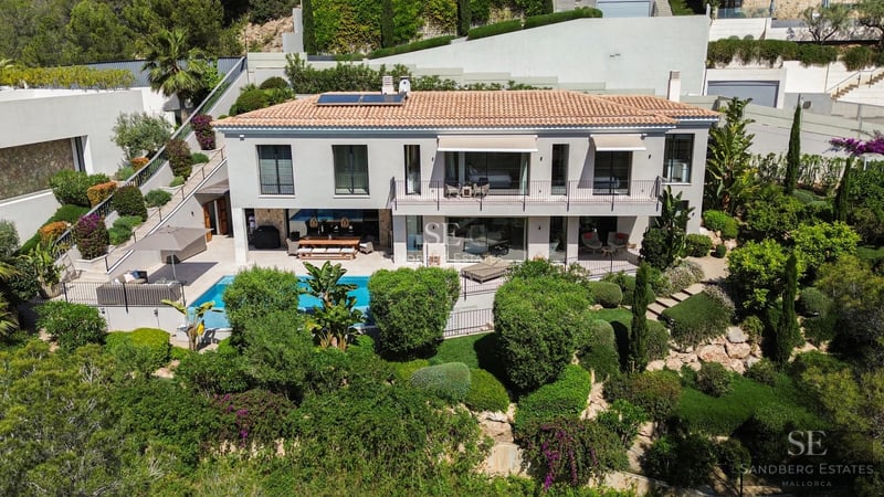 Exterior view of a modern villa with infinity pool. Minimalist design, large windows and lush natural surroundings.
