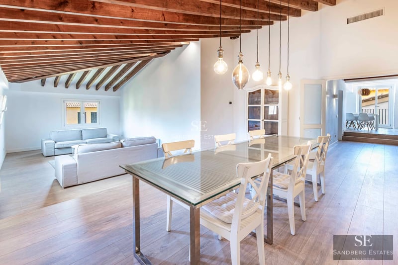 Ansicht eines Anwesens mit beleuchtetem Pool bei Sonnenuntergang. Moderne Architektur, weitläufige Terrassen und üppige Vegetation. Luxus und Komfort.