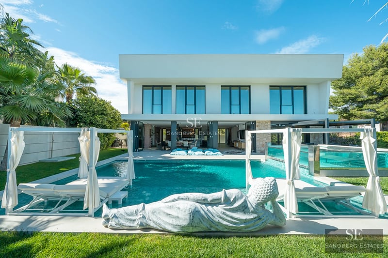 Exterior view of a modern house with pool. Minimalist architecture, large windows, manicured garden. Ambient lighting.