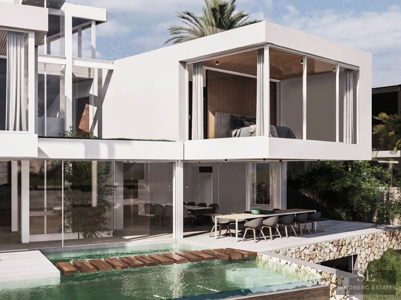 Modern white villa with an infinity pool, wooden stepping stones, and an outdoor dining area under a cantilevered roof.