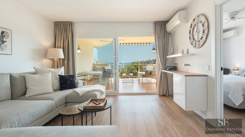 Spacious living room with windows, reflecting pool and modern design. Elegant finishes and abundant natural light. Sophisticated and relaxing space.