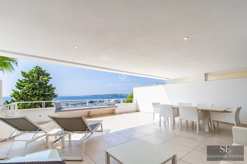 Exterior view of a modern villa featuring a reflective pool, large windows, and minimalist design. Manicured garden and contemporary architecture.