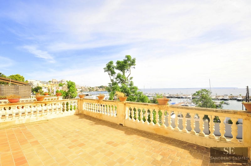 Spacious balcony with panoramic sea views. Modern design, glass railing, and elegant outdoor furniture.