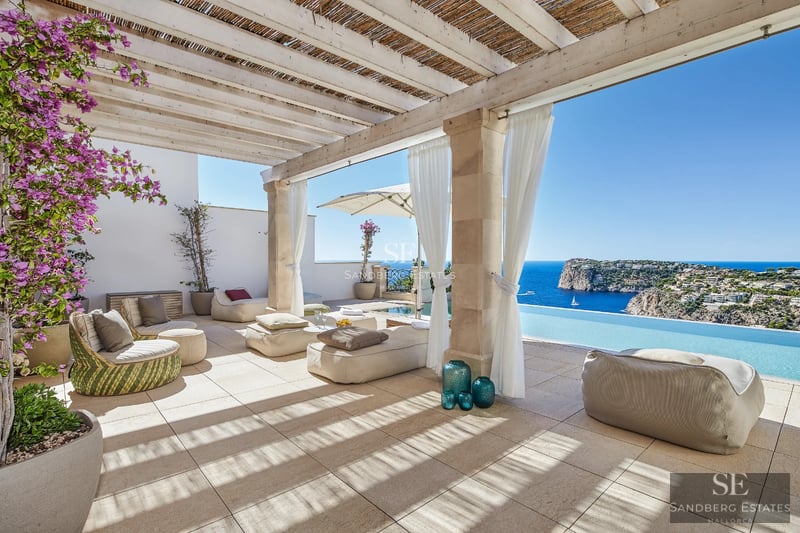 Exterior view of a modern villa with an infinity pool, lush garden, and spacious terraces. Elegant architecture and landscaping.