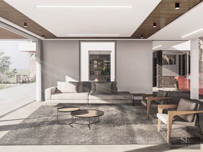 Minimalist living room with a grey sofa, wooden armchairs, and floor-to-ceiling windows showing a bright outdoor area.