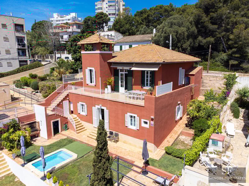 Luftaufnahme einer terracottaroten Villa mit privatem Pool, Garten und weitläufigen Terrassen.