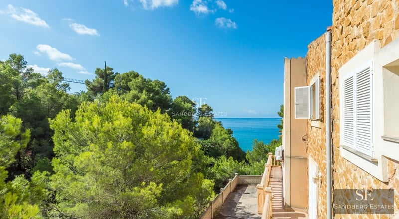 Spacious living room with large windows, reflecting pool and lush garden. Modern design, luxurious finishes and abundant natural light.
