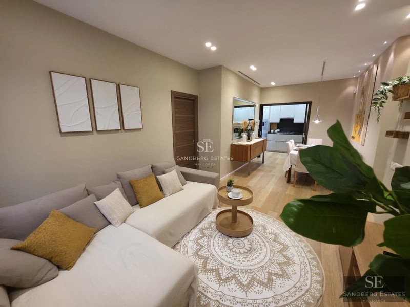 Exterior view of a modern villa with infinity pool, wooden deck, and large glass windows. Lush garden with tropical vegetation.