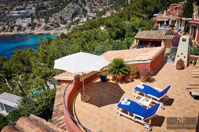 Exterior of a modern villa with infinity pool, spacious terraces and sea views. Minimalist and elegant architectural design.