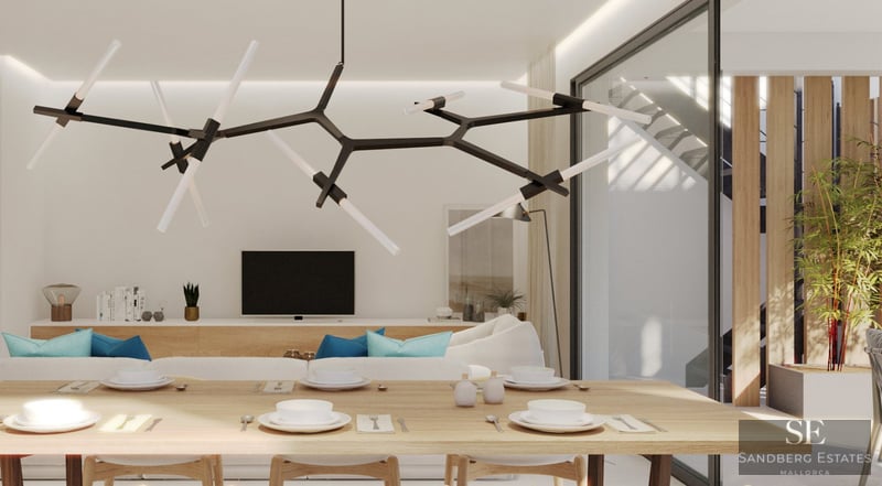 En modern matsal med ett stort träbord och designbelysning, som öppnar upp mot ett ljust vardagsrum.