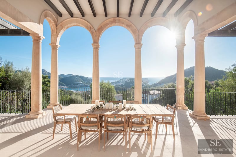 View from balcony with glass railing, infinity pool and sea in the background. Modern and elegant design. Decorative plants.