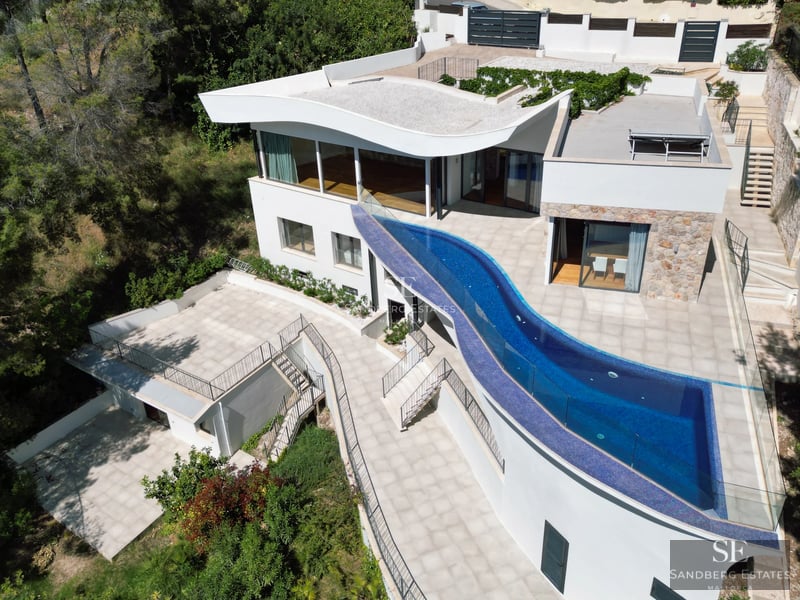 Bright living room with floor-to-ceiling windows offering sea view. Modern furniture, light wood floors and access to the terrace. Elegant minimalist design.