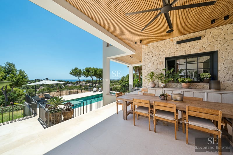 Vue d'une villa moderne avec piscine à débordement, jardin luxuriant et design architectural minimaliste. Éclairage doux et ambiance sereine.
