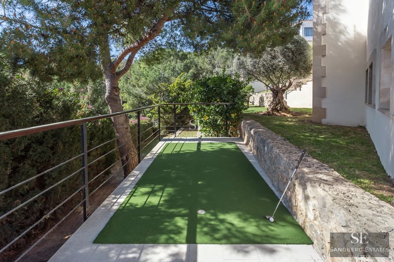Bright living room with large windows, beige sofa, modern fireplace, and panoramic sea views. Elegant and minimalist design.