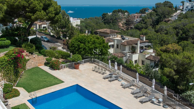 Exterior view of a modern villa with a pool, lush garden, and elegant architecture. Contemporary design with large windows.