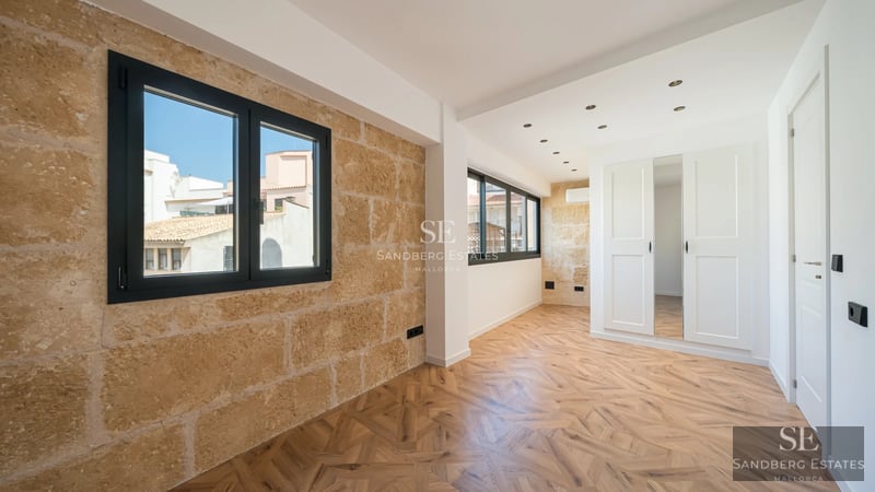 Außenansicht einer modernen Villa mit Infinity-Pool, Holzterrasse, üppigem Garten und großen Fenstern, die natürliches Licht hereinlassen.