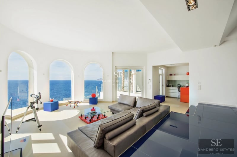 Spacious balcony with panoramic sea views. Modern design, glass railing, stylish outdoor furniture. Ambient lighting.