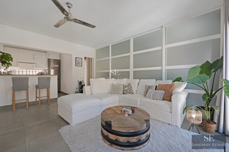 Spacious living room with floor-to-ceiling windows, fireplace, and modern design. Natural light and exterior views. Wood floors, light walls.