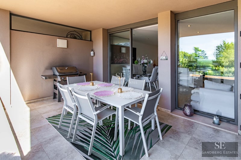 Vista exterior de una villa moderna con piscina, arquitectura limpia y minimalista, abundante luz natural y paisajismo cuidado.