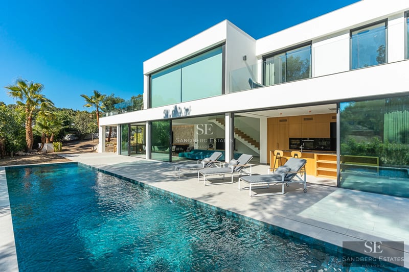 Exteriör av modern villa med pool, gräsmatta och stora fönsterpartier. Minimalistisk design med rena linjer och rikligt med naturligt ljus.