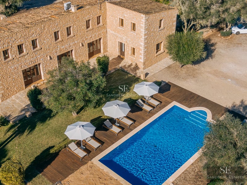 Panoramic view of a modern villa featuring a pool, lush garden, and minimalist architecture. Large windows and a sunny terrace.