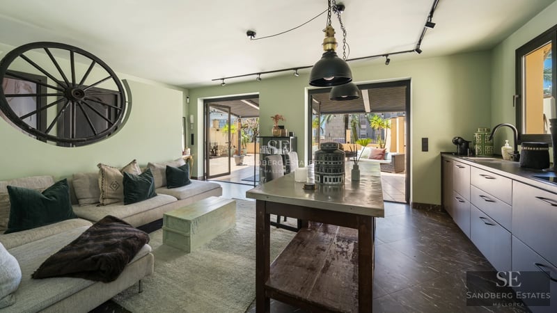 Spacious bright living room with large windows, wooden floors, and garden view. Modular grey sofa and modern decor.