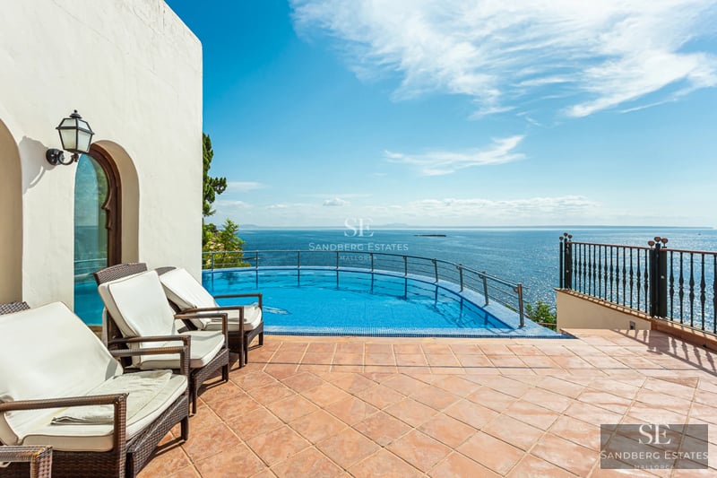 Vue panoramique d'une villa luxueuse avec piscine, jardin et architecture moderne. Grandes baies vitrées et design minimaliste.