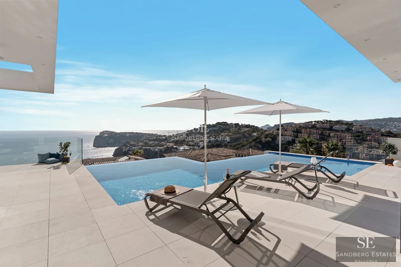 Exterior view of a modern villa with a pool, terrace, and expansive garden. Minimalist architecture with large windows.