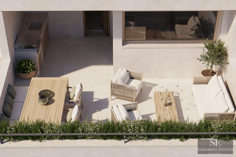 Bird's eye view of a sunlit modern terrace featuring a lounge area, dining table, and outdoor kitchen with a grill.
