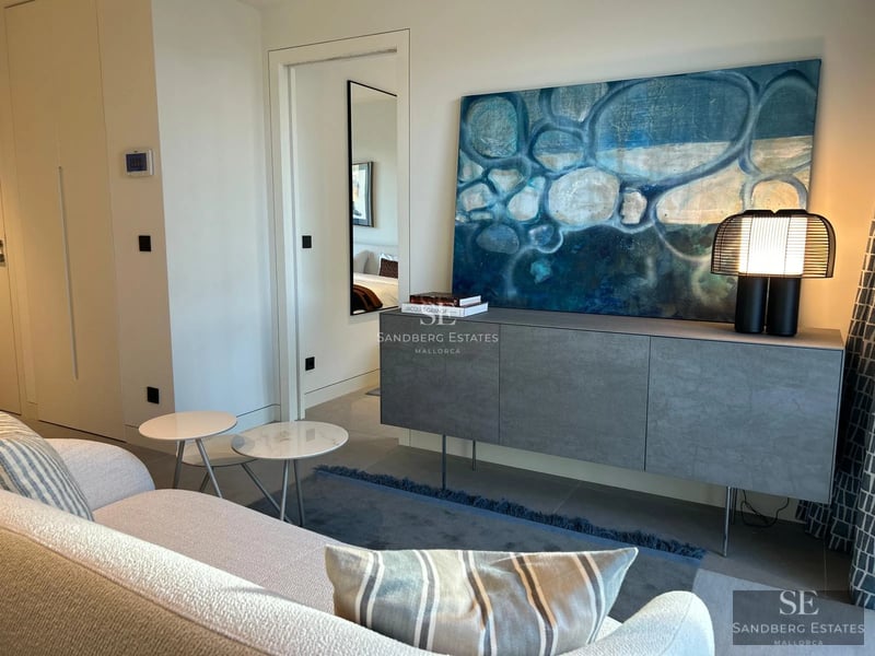 Modern facade with reflecting pool, large windows, minimalist landscaping and ambient lighting.