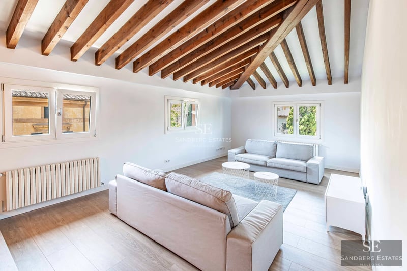 Helles Wohnzimmer mit großen Fenstern, modernen Möbeln und Zugang zu einer Terrasse. Panoramablick. Minimalistische Dekoration.