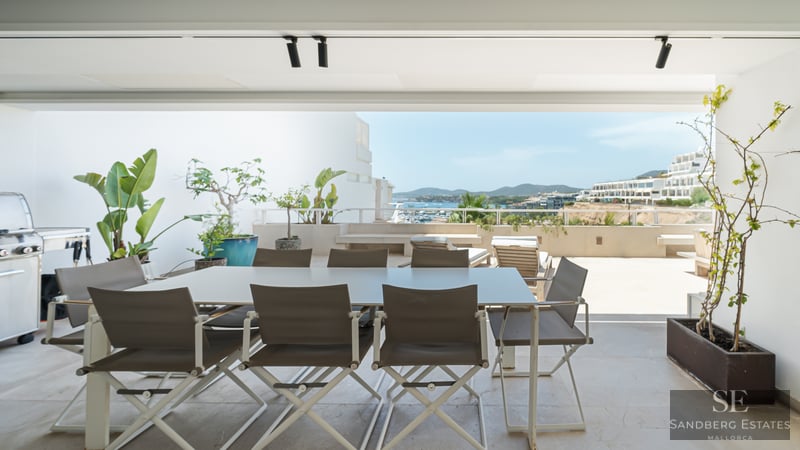 Moderne Terrasse mit Essbereich, Grill und Panoramablick auf die Küstenstadt und das Meer.