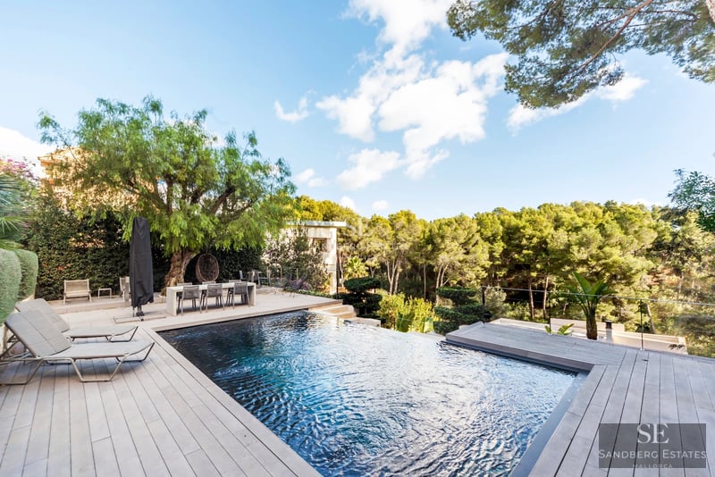Spacious pool surrounded by lush garden and modern architecture. Panoramic views and exclusive design details.