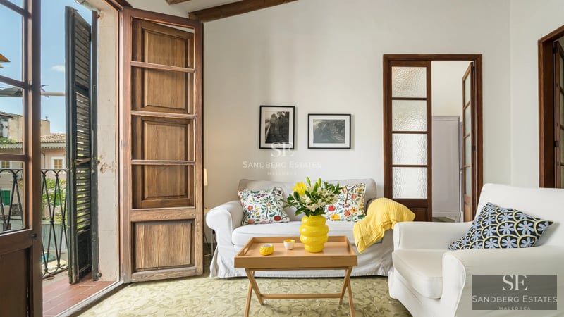 View of infinity pool with glass railings and lush garden, part of a luxurious, modern villa with sea views.