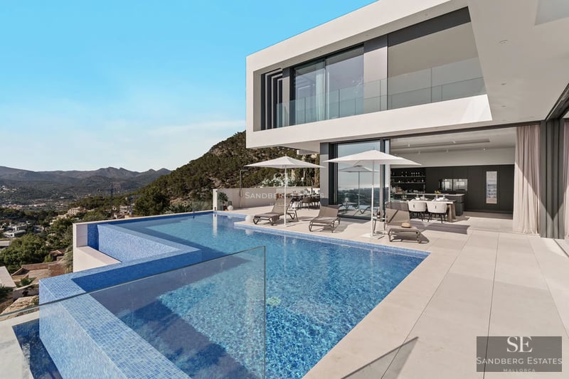 Exterior view of a modern villa featuring a pool, manicured garden, and expansive terraces. Minimalist architectural design with clean lines.
