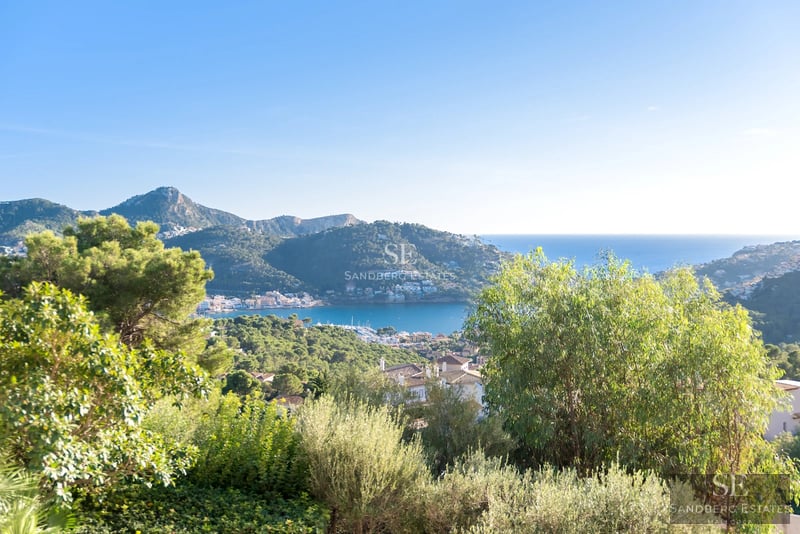 Exterior view of a modern villa featuring a pool, lush garden, and minimalist architecture. Large windows reflecting sunlight.