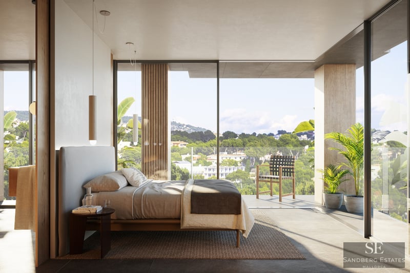 Bright master bedroom with floor-to-ceiling windows overlooking a lush landscape and a private terrace.