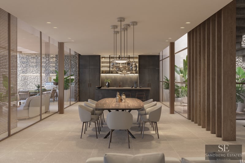 Elegant matsal med träbord, designerlampor och glasväggar mot en innergård.