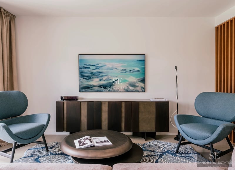 Spacious living room with large windows, panoramic sea views, modern furniture, and light wood floors.