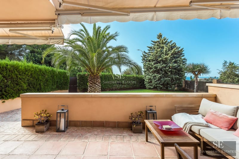 Exterior view of a modern villa with an infinity pool, lush garden, and spacious patio. Minimalist architecture and elegant design.