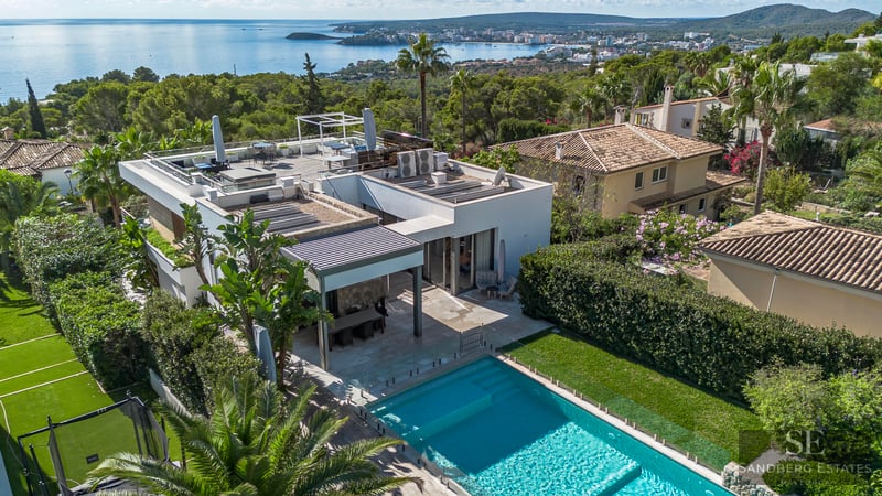Vue aérienne d'une villa blanche moderne avec piscine, terrasse et vue panoramique sur la mer Méditerranée.